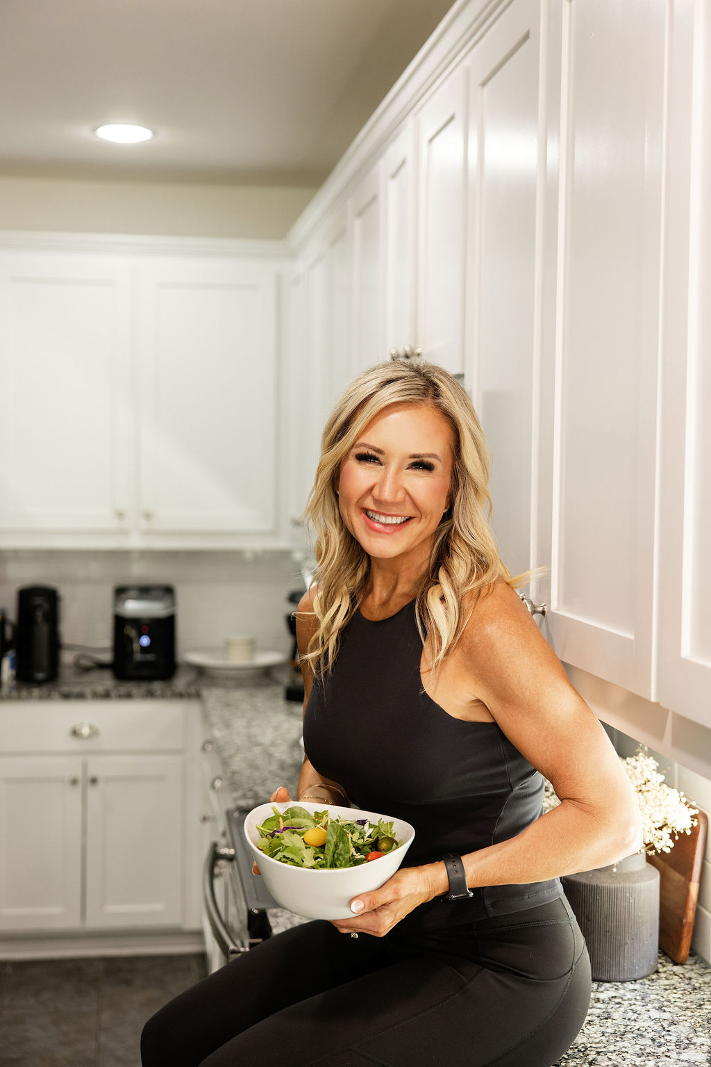 Janna Weaver holding a bowl of salad in her kitchen