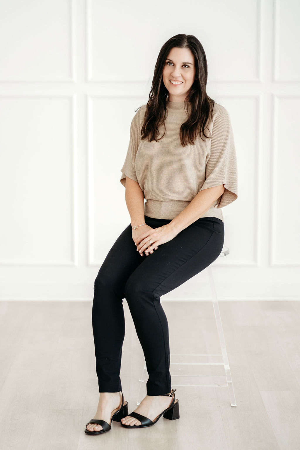 Jenny seated on a stool, smiling